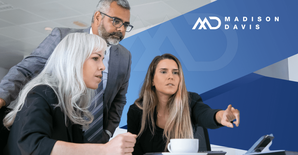 Three employees in corporate attire discuss risk management