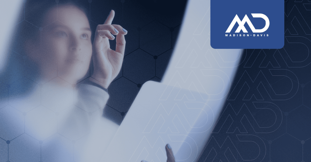 Female employee seen through frosted glass, holding a tablet and tapping an invisible screen